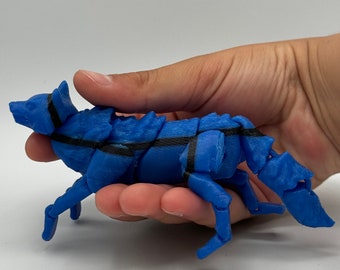 May include: A blue and black articulated 3D printed wolf figurine. The wolf is posed in a running position with its head turned to the side.