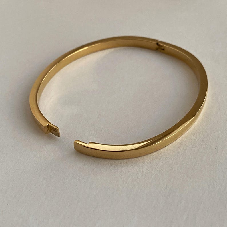 Peut inclure: Un bracelet jonc dor&eacute; avec une ouverture &agrave; charni&egrave;re.