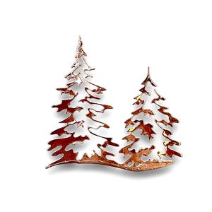 May include: A metal wall art sculpture of two stylized pine trees with a copper finish.