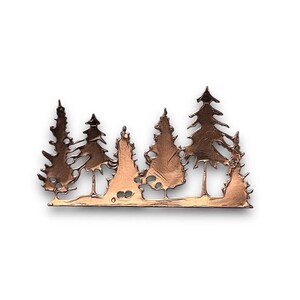 May include: A copper-coloured metal silhouette of a forest with five trees. The trees are stylised and have a rustic, weathered look.