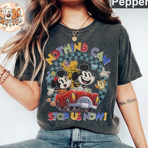 May include: A black t-shirt with a vintage-style graphic of Mickey Mouse, Minnie Mouse, and Pluto in a red car. The text "Nothing Can Stop Us Now!" is printed on the shirt.