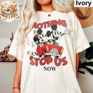 May include: A white oversized t-shirt with a graphic print of Mickey and Minnie Mouse driving a red car. The text "Nothing Can Stop Us Now" is printed below the image.