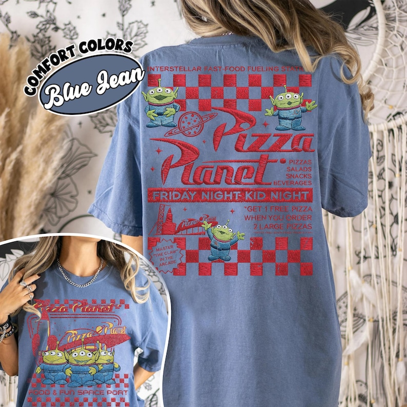 K&ouml;nnte beinhalten: Hellblaues T-Shirt in Comfort Colors mit einem Pizza Planet-Motiv. Das Design zeigt das Pizza Planet-Logo, Alien-Charaktere und den Text "Friday Night Kid Night".