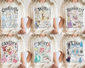 Könnte beinhalten: Sechs verschiedene T-Shirts mit Disney-Prinzessinnen. Jedes Shirt zeigt eine andere Prinzessin mit einem einzigartigen Design und Text. Die Shirts sind alle beige und haben kurze Ärmel.
