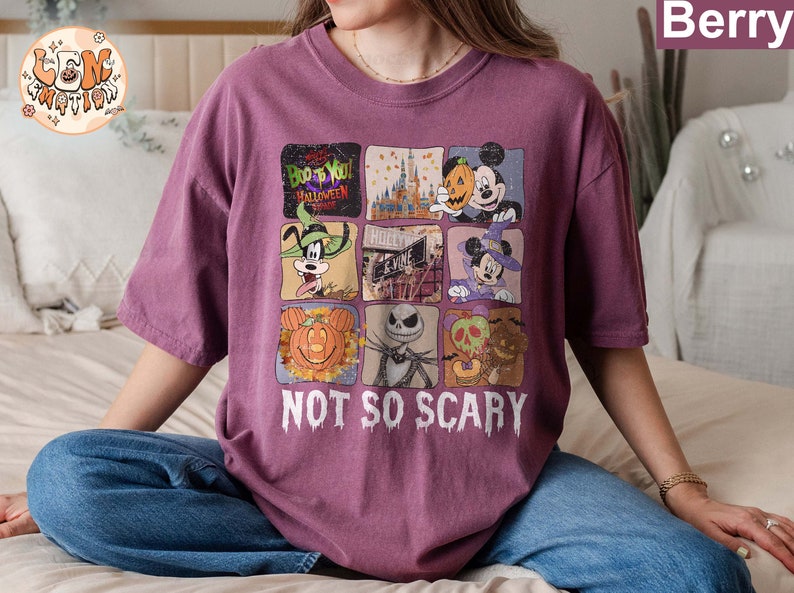 May include: A purple t-shirt with a graphic print of various Disney characters celebrating Halloween. The text "Boo to You! Halloween Time" and "Not So Scary" are printed on the shirt.