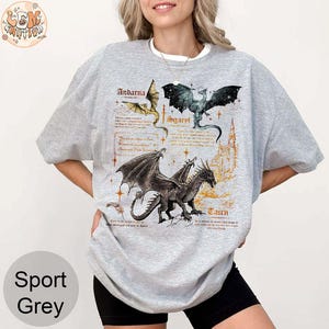 May include: A gray t-shirt with a graphic print of three dragons. The dragons are named Andarna, Sgaevl, and Taucn. The text is in a medieval font.
