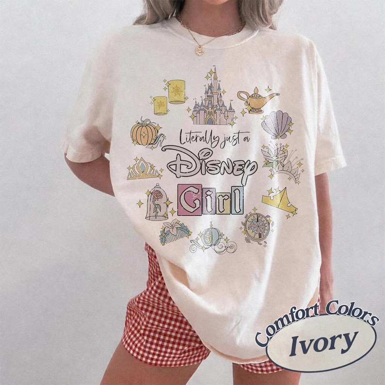 May include: Ivory-colored t-shirt with the text "Literally just a Disney Girl" surrounded by Disney-themed illustrations. The shirt features a crew neck and short sleeves. The shirt is made by Comfort Colors.