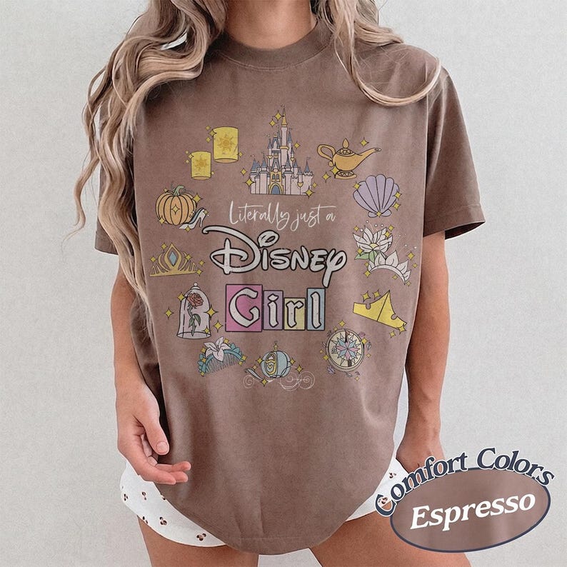 Op de afbeelding: Bruin T-shirt met de tekst "Literally just a Disney Girl" en Disney-illustraties. Het shirt is Comfort Colors Espresso van kleur en heeft een ronde hals.