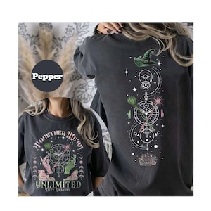May include: Black t-shirt with a graphic print of a witch's hat, stars, and a circle with the text "Together We're Unlimited Defy Gravity".