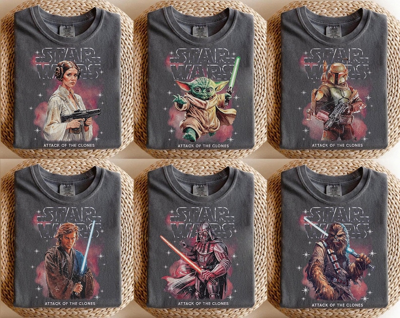 K&ouml;nnte beinhalten: Sechs graue T-Shirts mit Star Wars-Charakteren. Jedes Shirt hat das Star Wars-Logo und den Text "ATTACK OF THE CLONES". Zu den Charakteren geh&ouml;ren Prinzessin Leia, Yoda, Boba Fett, Anakin Skywalker, Darth Vader und Chewbacca.