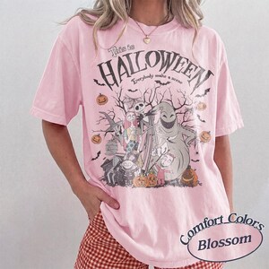 Pu&ograve; includere: T-shirt rosa chiaro con grafica di Halloween. Il design include personaggi, zucche e la scritta "This is Halloween". La maglietta &egrave; un Comfort Colors Blossom.