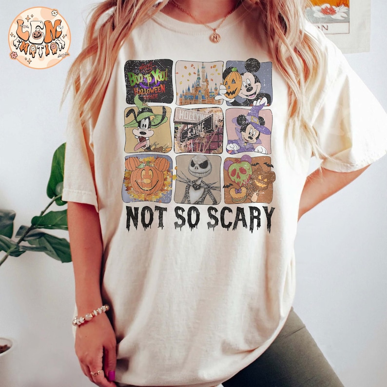 May include: A white t-shirt with a graphic of various Disney characters celebrating Halloween. The characters include Mickey Mouse, Goofy, Jack Skellington, and a pumpkin. The text "Boo to You! Halloween Spooktacular" and "Not So Scary" are printed on the shirt.