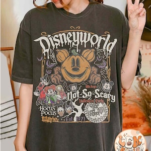 Op de afbeelding: Zwart T-shirt met een vintage-stijl afbeelding van Mickey Mouse als een pompoen, met de tekst "Disneyworld Mickey's Not-So-Scary Halloween Party Est. 1971" en afbeeldingen van andere Disney-personages.
