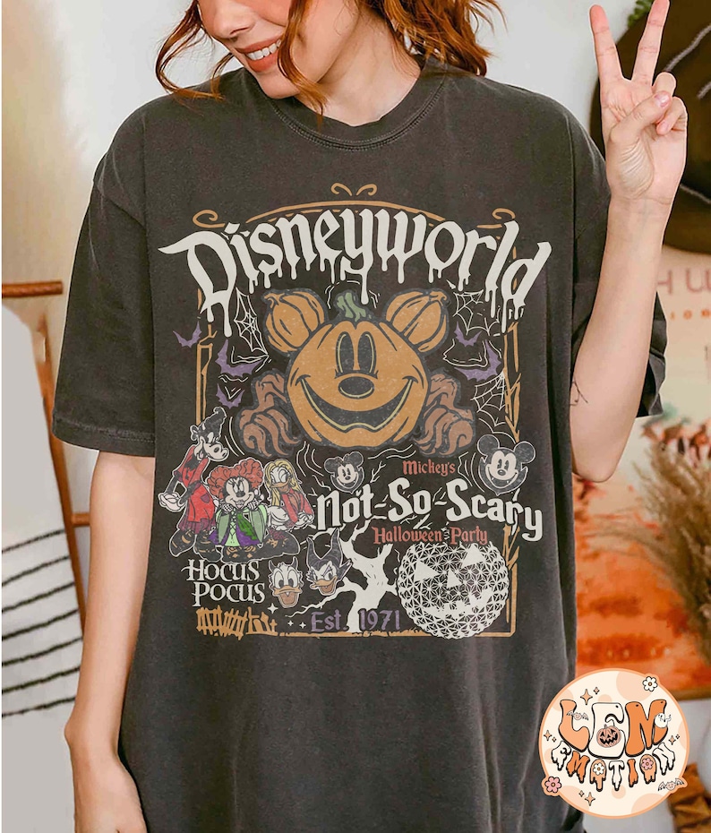 Op de afbeelding: Zwart T-shirt met een vintage-stijl afbeelding van Mickey Mouse als een pompoen, met de tekst "Disneyworld Mickey's Not-So-Scary Halloween Party Est. 1971" en afbeeldingen van andere Disney-personages.