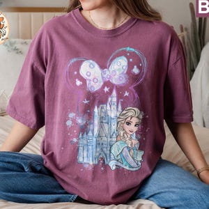 Puede incluir: Una camiseta morada con un estampado gr&aacute;fico de un castillo, un lazo y una princesa con cabello rubio. El texto "Berry" est&aacute; en la esquina superior derecha de la imagen.