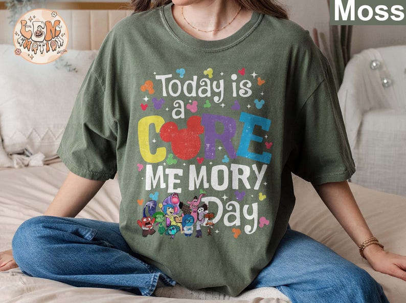 以下が含まれることがあります： 緑色のTシャツに、カラフルなグラフィックがプリントされています。「Today is a CORE MEMORY Day」という文字と、COREの文字の中にミッキーマウスの頭が描かれています。グラフィックには、映画「インサイド・ヘッド」のキャラクターも描かれています。