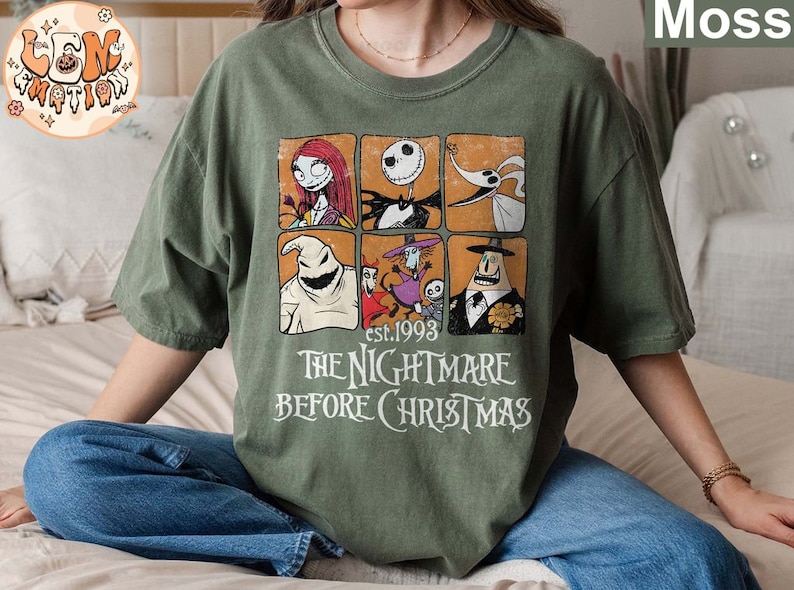 May include: A green t-shirt with a vintage-style graphic of characters from the movie "The Nightmare Before Christmas". The graphic includes Jack Skellington, Sally, Oogie Boogie, and Zero. The text "est. 1993" and "The Nightmare Before Christmas" is printed below the graphic.