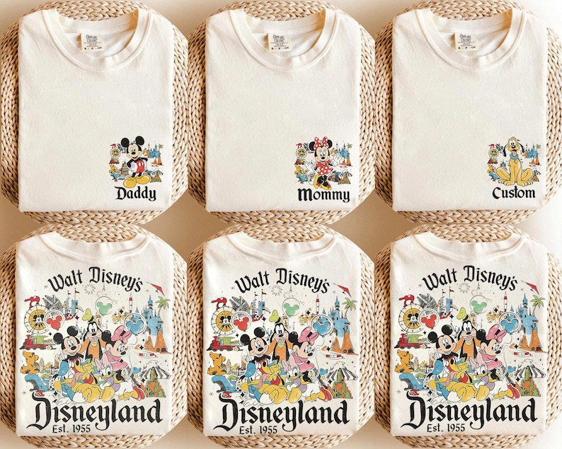 Puede incluir: Camisetas de color crema con gr&aacute;ficos de personajes de Disney. La fila superior presenta camisetas con las etiquetas "Daddy", "Mommy" y "Custom". La fila inferior muestra camisetas con un gr&aacute;fico de Disneyland y el texto "Est. 1955."