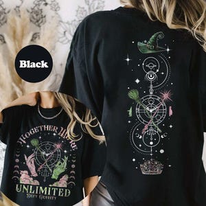 May include: Black t-shirt with a graphic print of a witch's hat, broom, and wand with the text "Together We're Unlimited Defy Gravity".