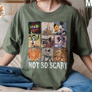May include: Green t-shirt with a multi-colored graphic print of various Disney characters and the text "Boo to You! Halloween Time" and "Not So Scary".