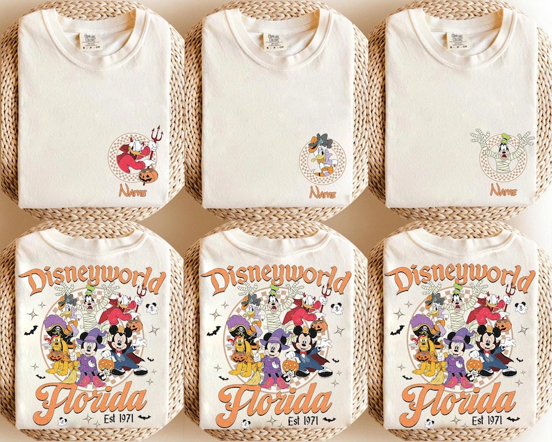May include: Cream-colored t-shirts with Disney character designs. The shirts feature Donald Duck, Goofy, and Mickey Mouse in Halloween costumes. The bottom shirts have a "Disneyworld Florida Est 1971" graphic.