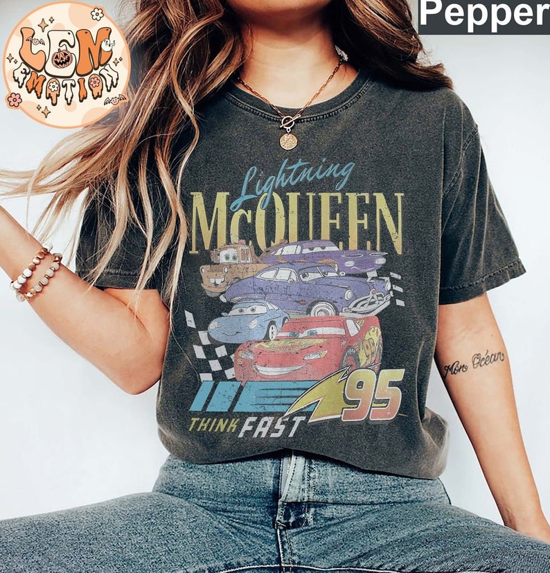 May include: A black t-shirt with a vintage-style graphic of Lightning McQueen from the Cars movie. The graphic features McQueen's number 95 and the text "Lightning McQueen" and "Think Fast".