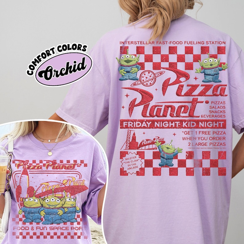 K&ouml;nnte beinhalten: Ein helllila T-Shirt mit dem Pizza Planet-Logo und Alien-Charakteren. Auf der R&uuml;ckseite des Shirts befindet sich ein rot-wei&szlig; kariertes Muster mit dem Text "Friday Night Kid Night". Das Shirt ist mit "Comfort Colors Orchid" gekennzeichnet.