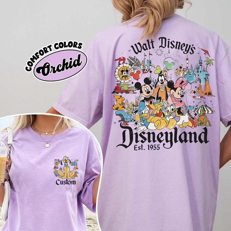 Puede incluir: Camiseta de color lila claro con un gr&aacute;fico de Disneyland en la espalda con Mickey Mouse, Minnie Mouse y otros personajes de Disney. El bolsillo delantero tiene un gr&aacute;fico de Pluto. La camiseta tiene el texto "Comfort Colors Orchid" y "Custom".