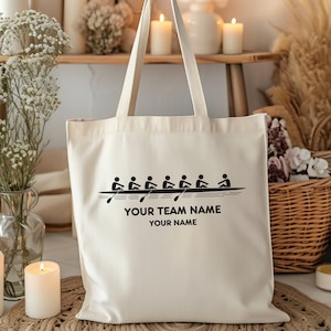 Puede incluir: Una bolsa de lona blanca con texto negro y un gráfico de un equipo de remo. El texto dice "Your Team Name" y "Your Name".