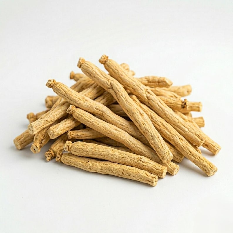 May include: A pile of dried ginseng roots, tan in color, against a white background. The roots are long and cylindrical, with a rough, textured surface. The image is well-lit, highlighting the natural color and texture of the ginseng.