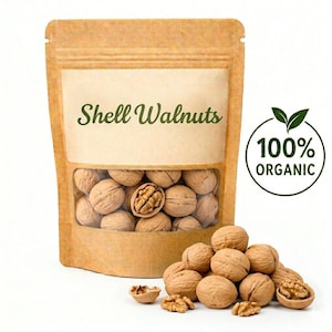Könnte beinhalten: Ein brauner Papiersack mit einem transparenten Fenster, gefüllt mit Walnüssen mit Schale. Der Beutel trägt den Text "Shell Walnuts" und ein Etikett "100% Organic". Ein Haufen Walnüsse liegt vor dem Beutel, einige sind aufgebrochen und zeigen das Nussfleisch.