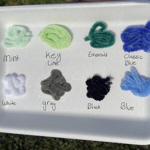 May include: A white foam tray with 10 small samples of colorful pipe cleaners. The colors are mint, key lime, emerald, classic blue, white, gray, black, and blue. The colors are labeled below each sample.