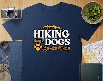 May include: Navy blue t-shirt with a white graphic that says "Hiking and Dogs Kinda Day" with a paw print and mountain silhouette.