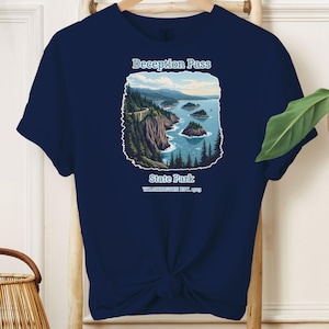 May include: Navy blue t-shirt with a graphic of Deception Pass State Park in Washington. The graphic features a scenic view of the park with a bridge, water, and trees.