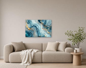 Op de afbeelding: Een rechthoekig wandkunstwerk met een abstract vloeiend ontwerp met wervelende tinten diepblauw, lichtblauw en wit, geaccentueerd door metallic gouden aders die een gemarmerd effect creëren over het gehele oppervlak van de print.