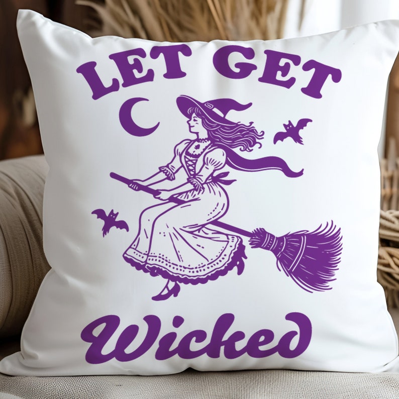 May include: White square cushion featuring a purple illustration of a witch on a broom, a crescent moon, and bats. The text "LET GET Wicked" is arched across the top and bottom.