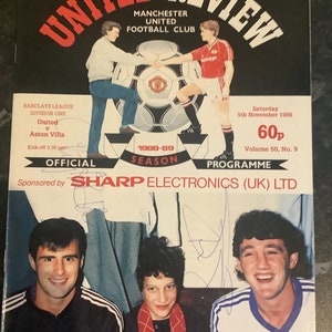 Può includere: Un programma di calcio del Manchester United del 5 novembre 1988, con una foto di tre giocatori e il testo "United Review" in rosso e bianco. Il programma è per una partita contro l'Aston Villa e costa 60 pence.