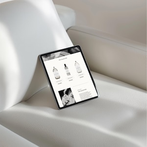 May include: A tablet computer displaying a website for a home fragrance collection. The website features a black and white image of a bottle of fragrance and the text "THE COLLECTION".