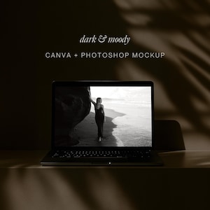 Puede incluir: Un portátil que muestra una imagen en blanco y negro de una persona en una playa. El portátil está sobre una superficie clara, con las palabras "dark & moody" y "CANVA + PHOTOSHOP MOCKUP" encima.