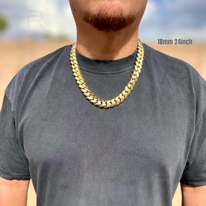 Man wearing an 18mm 24-inch Miami Cuban link chain in natural sunlight, showing the bold gold shine and tight link design.