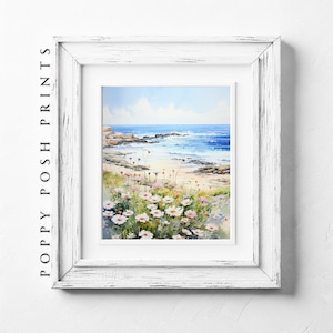 Puede incluir: Una pintura de acuarela de un paisaje marítimo con una costa rocosa, arena blanca y agua azul. En primer plano, un campo de flores blancas y rosas.