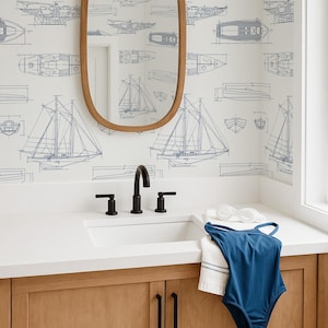 a bathroom with a sink, mirror, and a blue swimsuit hanging on the cabinet. The wall behind the sink has a repeating pattern of sailboat illustrations.