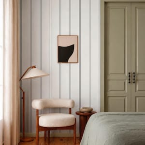 a modern bedroom with a striped wallpaper, a wooden chair, a bed, and a nightstand.