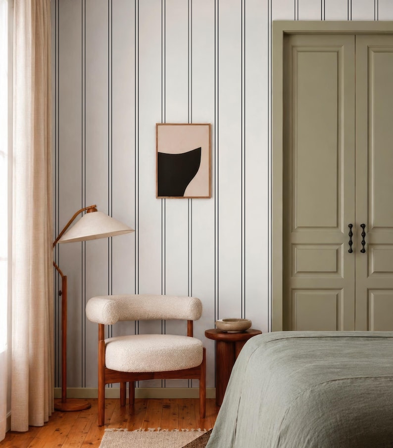 a modern bedroom with a striped wallpaper, a wooden chair, a bed, and a nightstand.
