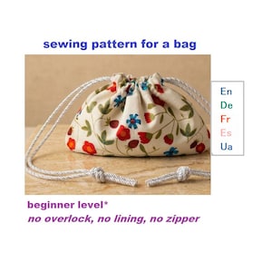 Puede incluir: Un patrón de costura de bolsa con cordón floral. La bolsa está hecha de tela color crema con patrones de flores y hojas rojas y azules. El texto de la imagen dice "sewing pattern for a bag", "beginner level" y "no overlock, no lining, no zipper".
