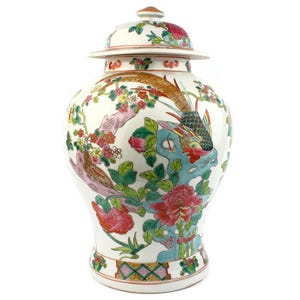Könnte beinhalten: Eine weiße Keramik-Ingwer-Vase mit Deckel, verziert mit bunten Blumen- und Vogelmotiven. Die Vase hat ein detailliertes Design mit rosa, roten, grünen und blauen Akzenten. Der Deckel ist mit einem goldfarbenen Knauf versehen.
