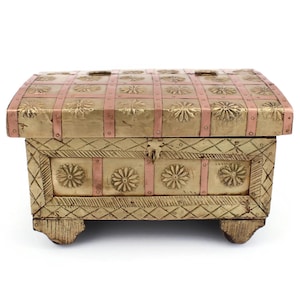 May include: A decorative wooden chest with a rectangular shape. The chest features a gold-colored finish with pink metal accents and floral designs. The chest is supported by four small feet.