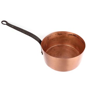 May include: A copper saucepan with a long, dark metal handle. The pan has a rounded base and a slightly flared rim. The handle is riveted to the side. The interior of the pan shows signs of use.