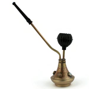 May include: An antique brass hookah with a black bowl and mouthpiece. The hookah features intricate floral engravings and decorative stones. The long, curved stem extends from the base to the mouthpiece.