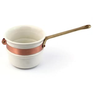 Puede incluir: Cacerola blanca pequeña con una banda de cobre y un mango largo de latón. El mango tiene un lazo en el extremo para colgar. La cacerola está diseñada para cocinar y probablemente se usa para salsas o porciones pequeñas.